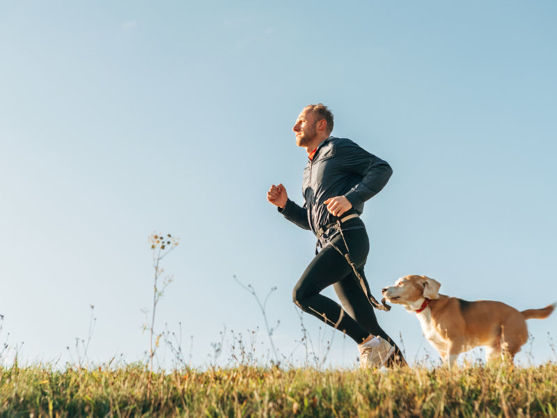 Man running outside with dog